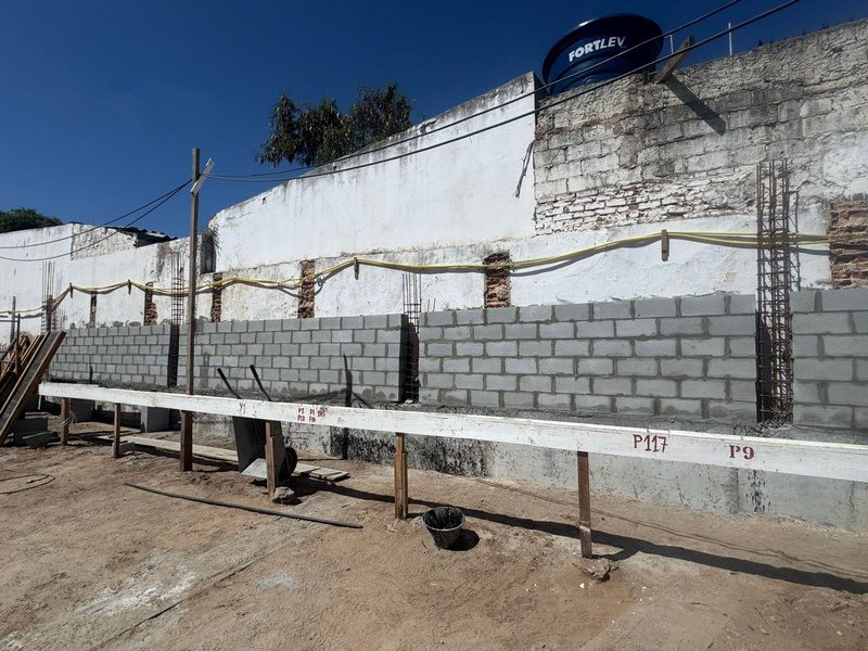 Muro de alvenaria do subsolo em execução, ao longo da divisa.