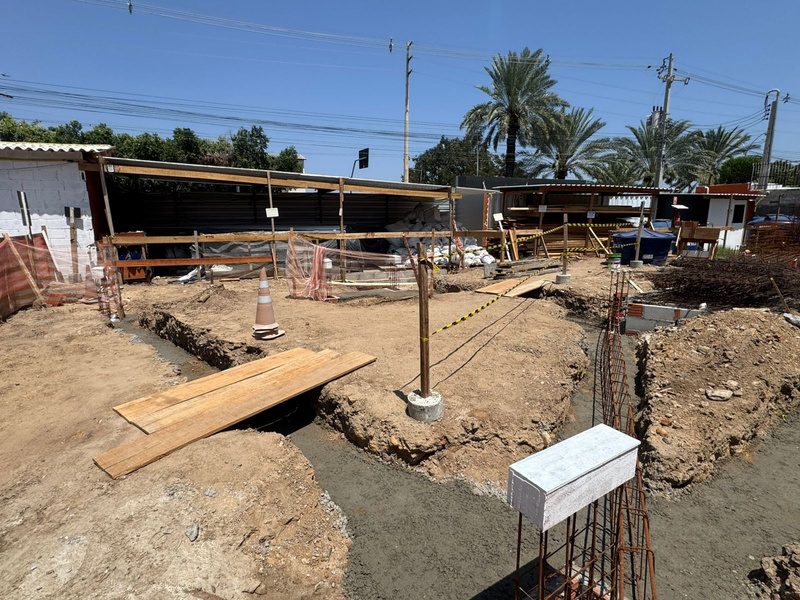 Serviços de fundação na periferia do terreno, com reservatório ao fundo.